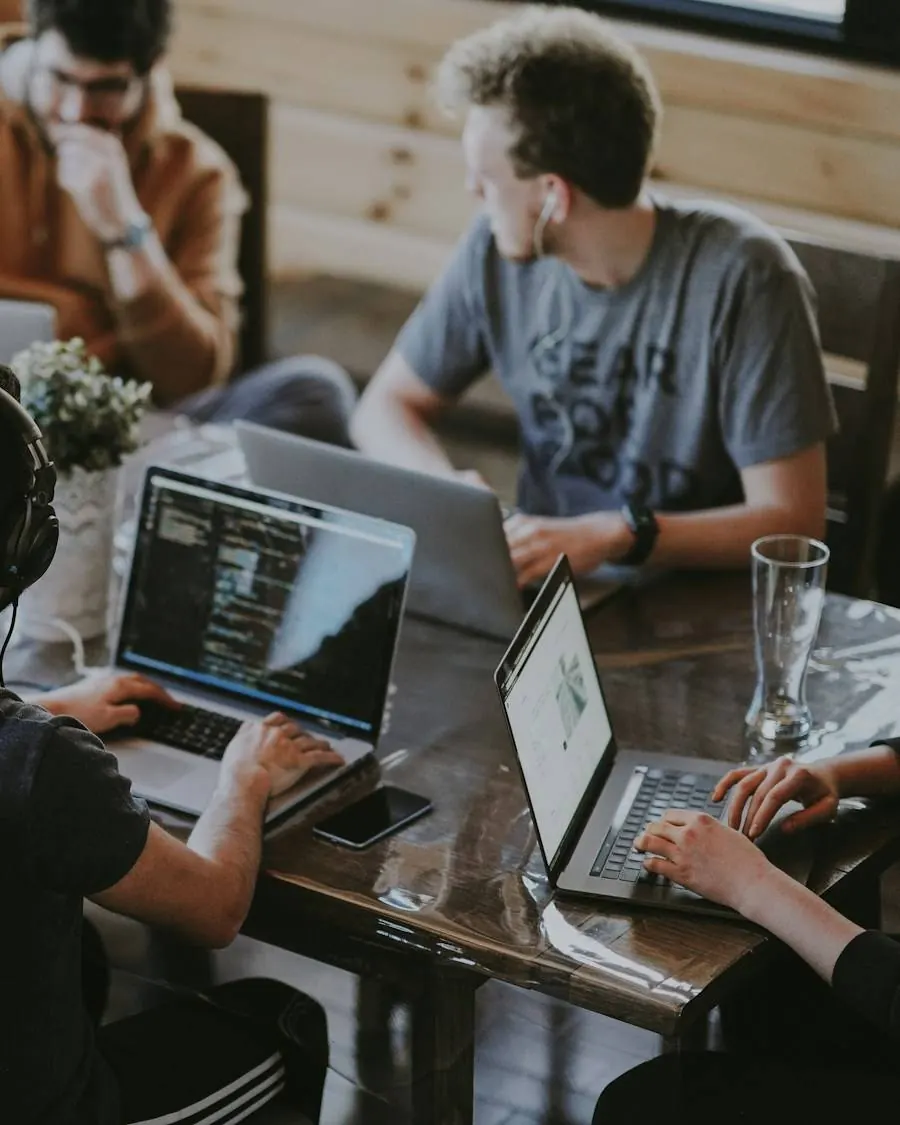 A development team collaborating around a table with laptops