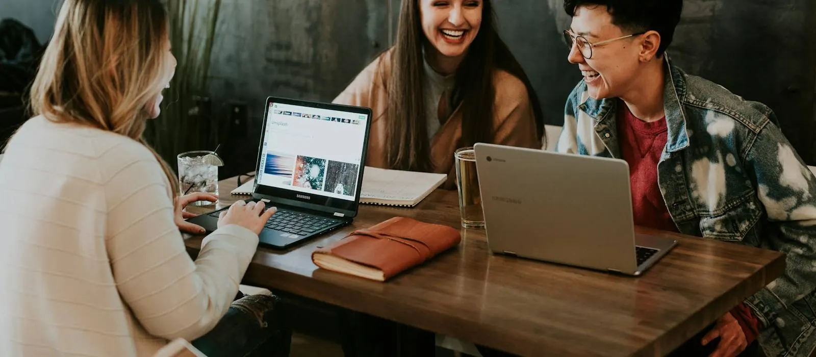 Colleagues smiling while working together at a laptop