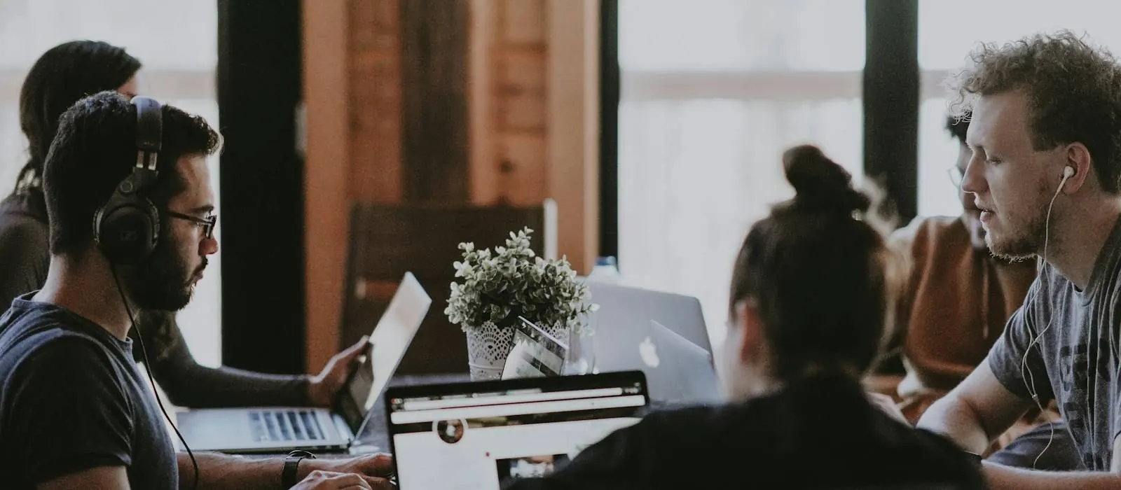 Software developers working together at laptops in an office